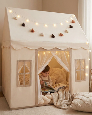 Child reading inside the play tent with fairy lights